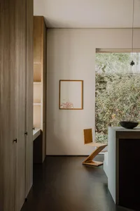 A minimalist residential kitchen featuring wood and concrete materials.