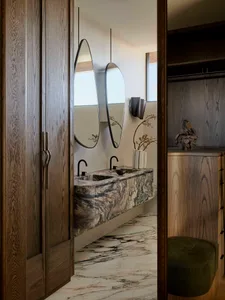 A modern bathroom suite featuring a marble vanity and two mirrors.