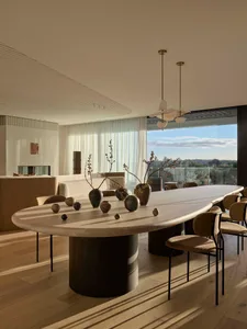 Modern dining room featuring wooden table and chairs, with a mix of geometric and organic shapes, and a minimalist design.