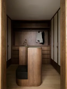 Modern wooden walk-in closet with minimalist design and built-in storage.