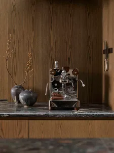 A sleek, modern kitchen featuring metallic appliances, wooden accents, and marble countertops.