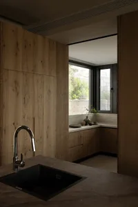 Modern residential kitchen with wooden cabinets and black countertop sink