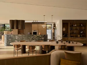 Modern living, dining, and kitchen area featuring wood, marble, and metal elements.