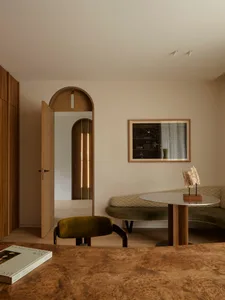 A modern living room featuring melamine veneer furniture and a round dining table with a reflective surface.