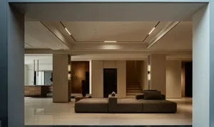 A modern, minimalist residential interior featuring sleek, metallic furniture, concrete and marble flooring, and a sophistica