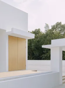 A modern minimalist white exterior featuring wooden doors and a sleek design.