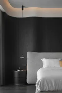 A modern bedroom featuring a textured fabric headboard and minimalist design elements.