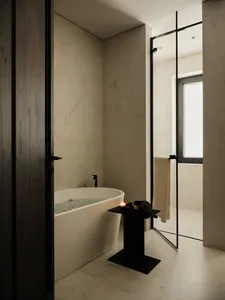 Modern minimalist bathroom featuring white marble appliances and a freestanding bathtub.