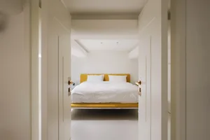 Modern, minimalist bedroom with neutral tones and contemporary decor.