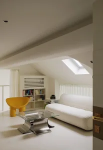 A minimalist living room with white furniture and white walls.