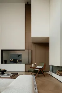 現代簡約客廳，採用俐落木質內裝，搭配壁爐與當代座椅。