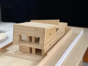 A wooden architectural model of a modern residential house.