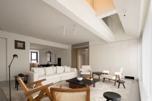 The interior design features a modern living room with a shared space layout and a mix of materials, including wood, leather,
