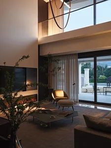 Modern interior design featuring living space with furniture made of metal, glass, and wood.