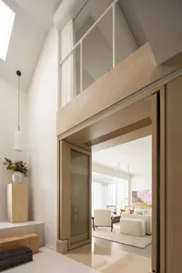 Modern living room featuring a wooden entrance and tall windows.