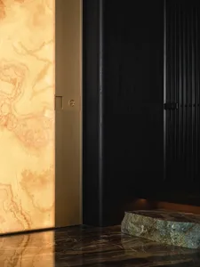 An elegant modern entrance hall with marble flooring and a textured wall.