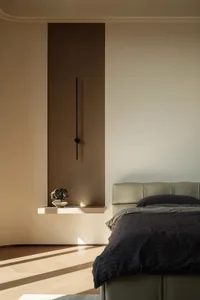 A modern minimalist bedroom featuring a neutral color palette, includes a minimalist bed frame and a floating shelf with a sm