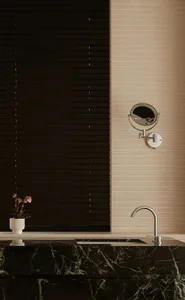 Modern minimalist bathroom with black marble countertop, mirror, and faucet.