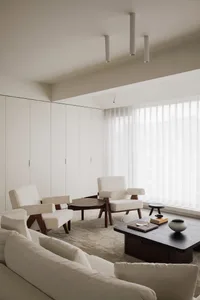 A modern living room with neutral-colored furniture and decor.