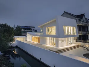A modern residential house with concrete and glass exterior materials.
