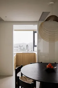 A modern residential kitchen featuring wooden cabinetry and a glass backsplash.