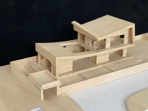 A wooden architectural model of a modern residential building.