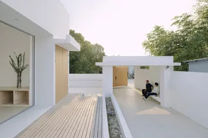 A modern house with white walls and a wooden deck.
