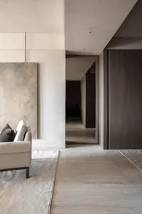 A minimalist living space featuring natural light, concrete flooring, and wood accents.