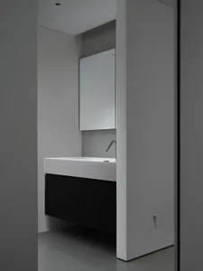 Compact modern bathroom with a ceramic sink, minimalistic design, and sleek, clean lines.