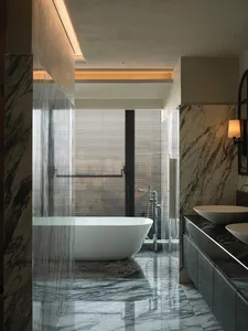 Modern bathroom with marble finishes and freestanding bathtub.
