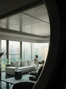 A modern living room with large windows overlooking a cityscape.