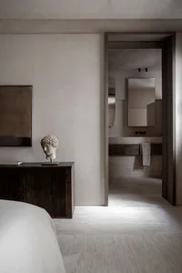 Modern minimalist bedroom with concrete and timber materials and a contemporary design.