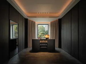 A modern office desk space with dark wooden cabinets and a central desk.