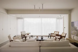 Modern living room with neutral-toned furniture and a large window.
