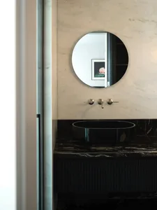Industrial-style modern bathroom with marble sink, faucet, and mirror.