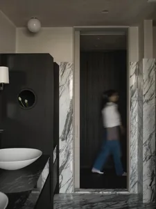 A modern bathroom with marble walls and wooden elements