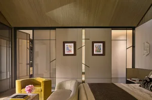 A modern bedroom with fabric walls, lighting, and light-colored walls.