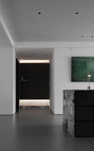 Modern interior space with marble accents and black wooden cabinets.