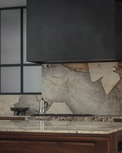 Modern kitchen featuring a sleek marble backsplash and countertop, with a stainless steel espresso maker on the countertop.
