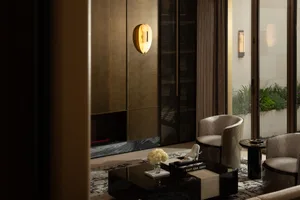 A modern living room with metallic elements and glass features.