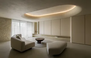 A modern living room with neutral-colored furniture and walls.