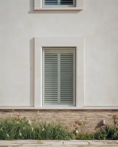 Window with white primative stucco and brick material