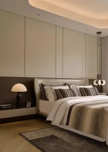 Modern minimalist bedroom with wooden floor, upholstered bed, fabric headboard, and glass pendant light.