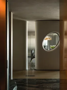 Modern dining room featuring a glass wall and metallic furniture, with a bouquet of flowers on the table.