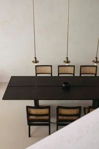 A modern dining room with a wooden table and chairs, minimalistic design and geometric shapes.