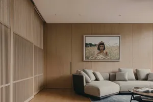 A modern living room featuring wood-paneled walls and a comfortable sectional sofa.