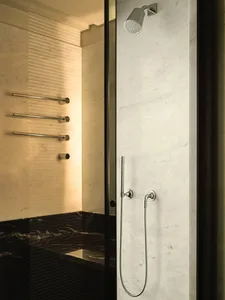 Modern bathroom featuring a shower area with marble walls and flooring.