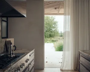 Modern minimalist kitchen with marble countertops and cabinets, featuring sleek design elements.