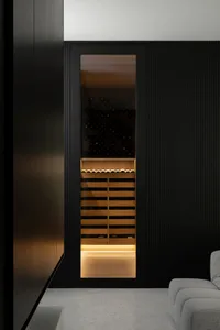 Modern minimalist design of a glassed-in wine cellar with wooden racks and metal accents.