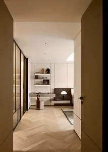 Modern office studio with light wood flooring, sleek shelving, and minimalist decor.